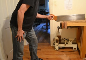Showing good form while using a 28 inch miter box saw with low hang.  The elbow has been lowered by crouching slightly and bending over, bringing the forearm into alignment with the wrist.