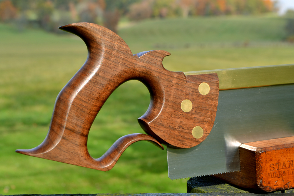 Closeup view of handle of 12 inch carcase saw in curly walnut